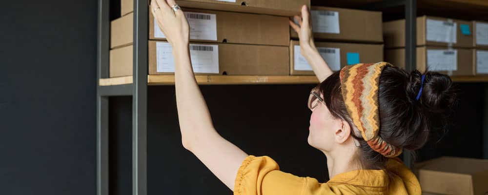 Lady stacking boxes in business storage in Chester